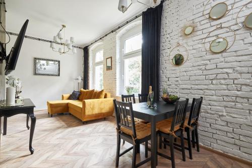 sala de estar con mesa y pared de ladrillo en Art Apartment Grzmiąca, en Grzmiąca