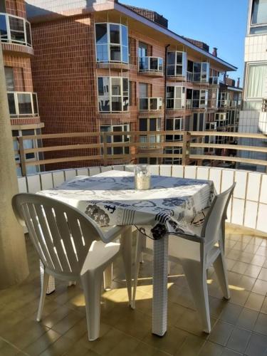 a table and chairs on a balcony with a building at Hondartza in Zarautz
