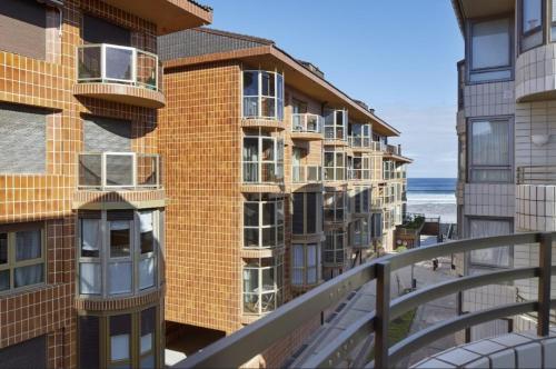 ein Apartmenthaus mit Balkonen und dem Meer im Hintergrund in der Unterkunft Hondartza in Zarautz