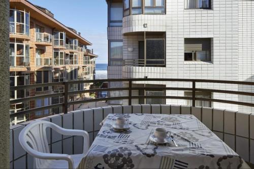 einen Tisch und Stühle auf einem Balkon mit Blick auf ein Gebäude in der Unterkunft Hondartza in Zarautz