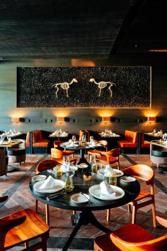a restaurant with tables and chairs and horses on the wall at Secrets Moxché Playa del Carmen - Adults Only - All Inclusive in Playa del Carmen