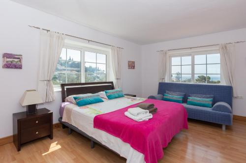 sypialnia z łóżkiem i niebieską kanapą w obiekcie Villa del Sol - Entre Tu y Yo w mieście Benalmádena