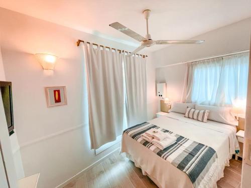 a bedroom with a bed and a ceiling fan at Tamanacos Hotel & Spa in Villa Gesell