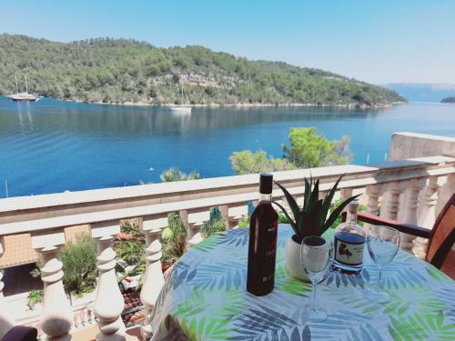 a table with a bottle of wine on a balcony at Apartments Sponga in Polače