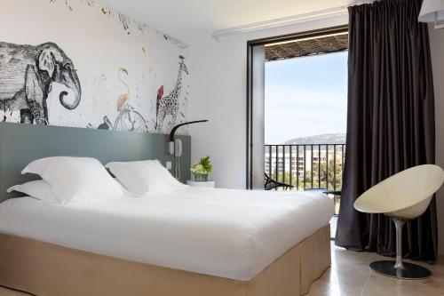 - une chambre avec un grand lit et une fenêtre dans l'établissement Hotel Alcyon, à Porto-Vecchio