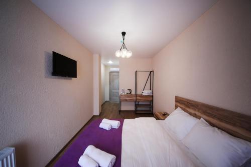 a bedroom with a bed with two towels on it at Bessarion Boutique Hotel in Kutaisi