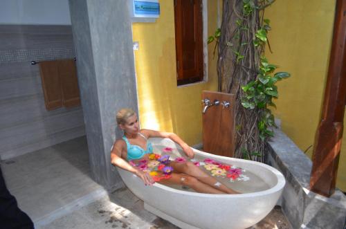 a woman sitting in a bath tub at Thambapanni Retreat in Unawatuna