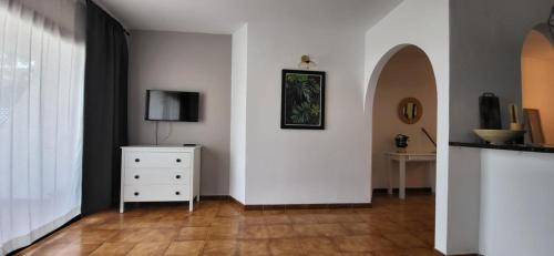 a living room with a television and a dresser at Albatros Tenerife Golf Sea View in San Miguel de Abona