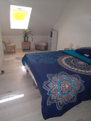 - une chambre avec un lit doté d'une couverture bleue dans l'établissement Maison neuve au calme, à Pleumeur-Bodou