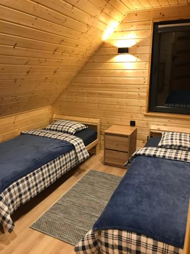 a room with two beds and a tv in a cabin at Domek Kątno in Kątno