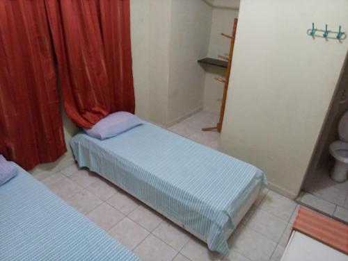 a small room with two beds and a window at Hotel Ouro Preto in João Pessoa