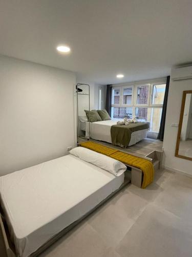 1 dormitorio con 2 camas y ventana en Merkat Center Alicante, en Alicante