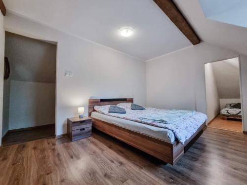 a bedroom with a large bed and a wooden floor at Chill House in Mrągowo
