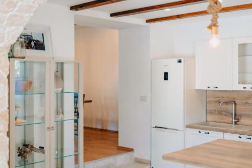 uma cozinha com armários brancos e um frigorífico em Paesana Heritage House em Garica