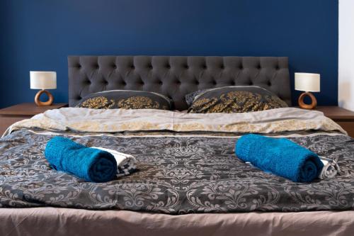 a bed with two blue pillows on it at Apartamenty Karkonosze Góry Izerskie in Piechowice