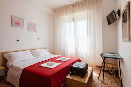 a bedroom with a bed with a red blanket at Hotel Villa del Mare in Senigallia