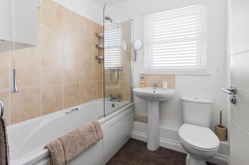a bathroom with a toilet and a sink and a tub at A modern and cosy apartment just yards from Brixham’s bustling harbourside in Brixham