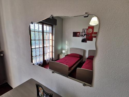 a mirror on the wall of a bedroom with a bed at Una finestra sul verde in Sassello