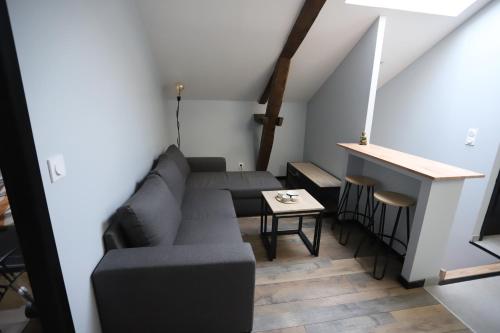a living room with a couch and a table at Appartement neuf climatisé in Aramits