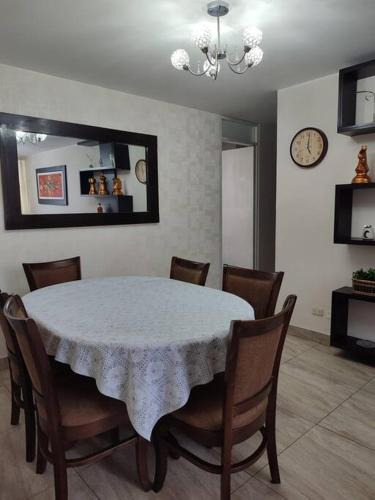 a dining room with a white table and chairs at Dpto entero, 2do piso, ascensor y cochera in Lima