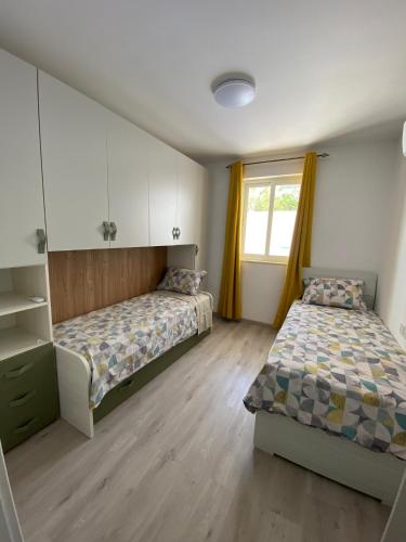 a bedroom with two beds and a window at Modern Apartment with Large Outdoor Area - Sleeps 7, Close to Malta International Airport in Luqa