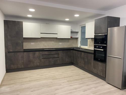 una cucina con armadietti bianchi ed elettrodomestici in acciaio inossidabile di Modern Apartment with Large Outdoor Area - Sleeps 7, Close to Malta International Airport a Luqa