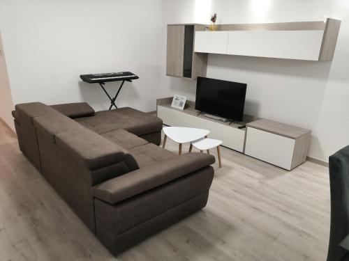 a living room with a couch and a television at Modern Apartment with Large Outdoor Area - Sleeps 7, Close to Malta International Airport in Luqa