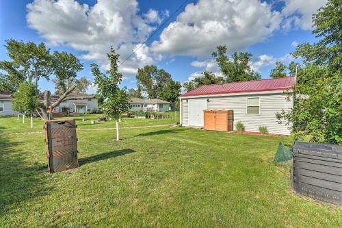 a yard with a white building and a tree at Kid-Friendly House about 8 Mi to Cedar Rapids! in Cedar Rapids