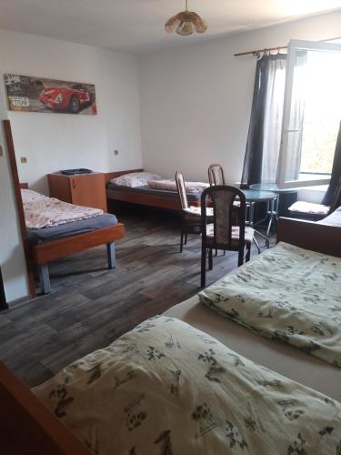 een kamer met 2 bedden en een tafel en stoelen bij Pension Family Club in Libišany