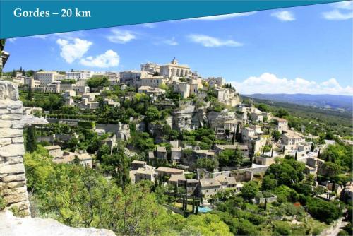 a city on top of a hill with houses at Les Bastidons de L'Isle - st ju- 3 étoiles in LʼIsle-sur-la-Sorgue