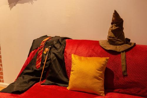 une veste noire et un oreiller jaune sur un canapé rouge dans l'établissement Le 7ème Art, à Lille