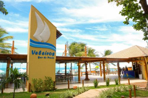 a sign in front of a resort with a large surfboard at Portobello Park Hotel in Porto Seguro