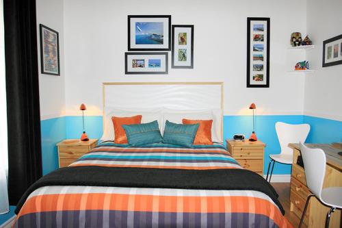 - une chambre avec un lit orange et bleu dans l'établissement Gite Confort, à Québec