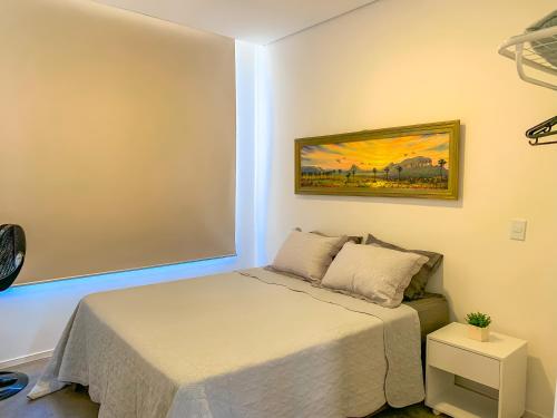 a bedroom with a bed and a painting on the wall at Villa Candombá in Alto Paraíso de Goiás