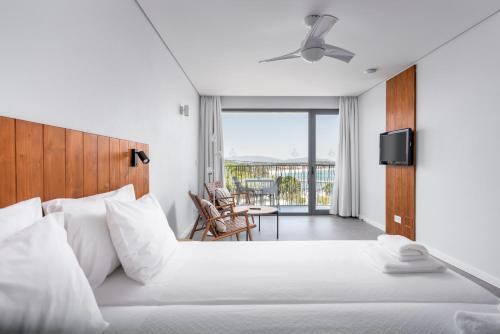a bedroom with a large bed and a balcony at Apartamentos Marvela in Lagos