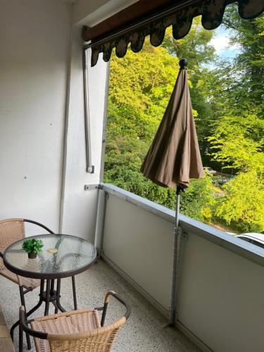 a balcony with a table and an umbrella at New Renovated and near Centrum in Lübeck