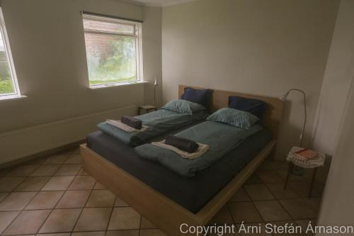 a bed in a room with two pillows on it at Villa apartment Hafnarfjordur - Ideal for Aurora in Hafnarfjörður
