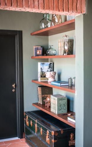 a room with a shelf with books and a trunk at Borgo San Vincenzo in Montepulciano
