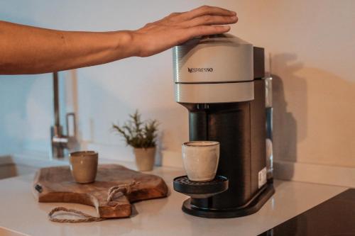 a person is pouring coffee into a coffee machine at Borgo San Vincenzo in Montepulciano