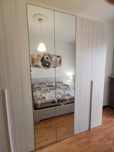 a bedroom with a mirrored closet with a bed in it at Una finestra sul verde in Sassello