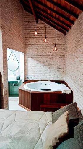 a large bathroom with a tub and a bed at Chalé Villa Magrini in Monte Verde