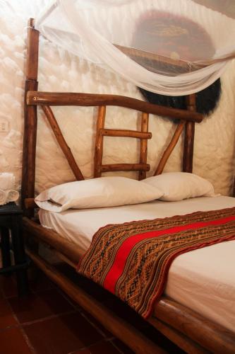 a bedroom with a bed with a wooden frame at Praba Hostel in Palomino