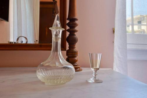 a glass vase and a glass cup on a table at History House in Corfu Town