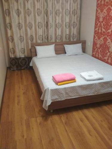 1 dormitorio con 1 cama con 2 toallas en 2-квартира Арбат Панфилова 32, en Almaty