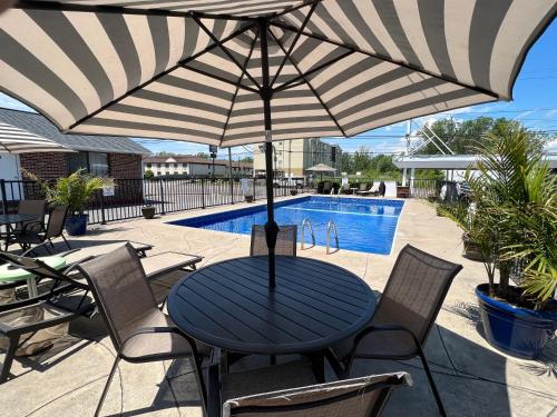 a table with an umbrella in front of a pool at Moonlite Motel in Niagara Falls