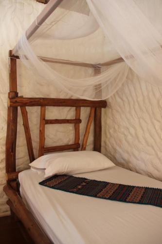 a bunk bed in a room with a mosquito net at Praba Hostel in Palomino