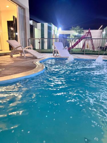 a swimming pool with two chairs and a roller coaster at Sydra Chalet in Riyadh