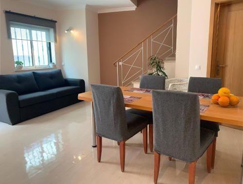 a dining room with a table and chairs and a couch at House with a BBQ terrace in the centre of Lagos in Lagos