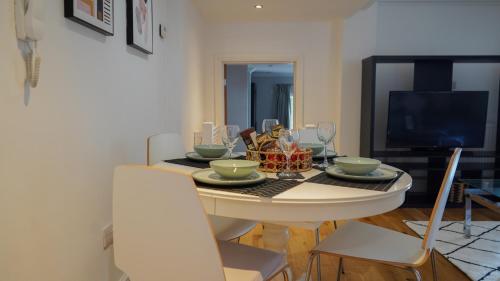 a dining room with a table with glasses on it at Modern & Spacious Leeds City Centre Apartment with Parking - Sleeps 5 in Leeds