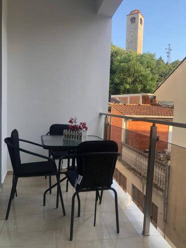 a balcony with a table and chairs and a clock tower at City Heart Apartments in Ulcinj